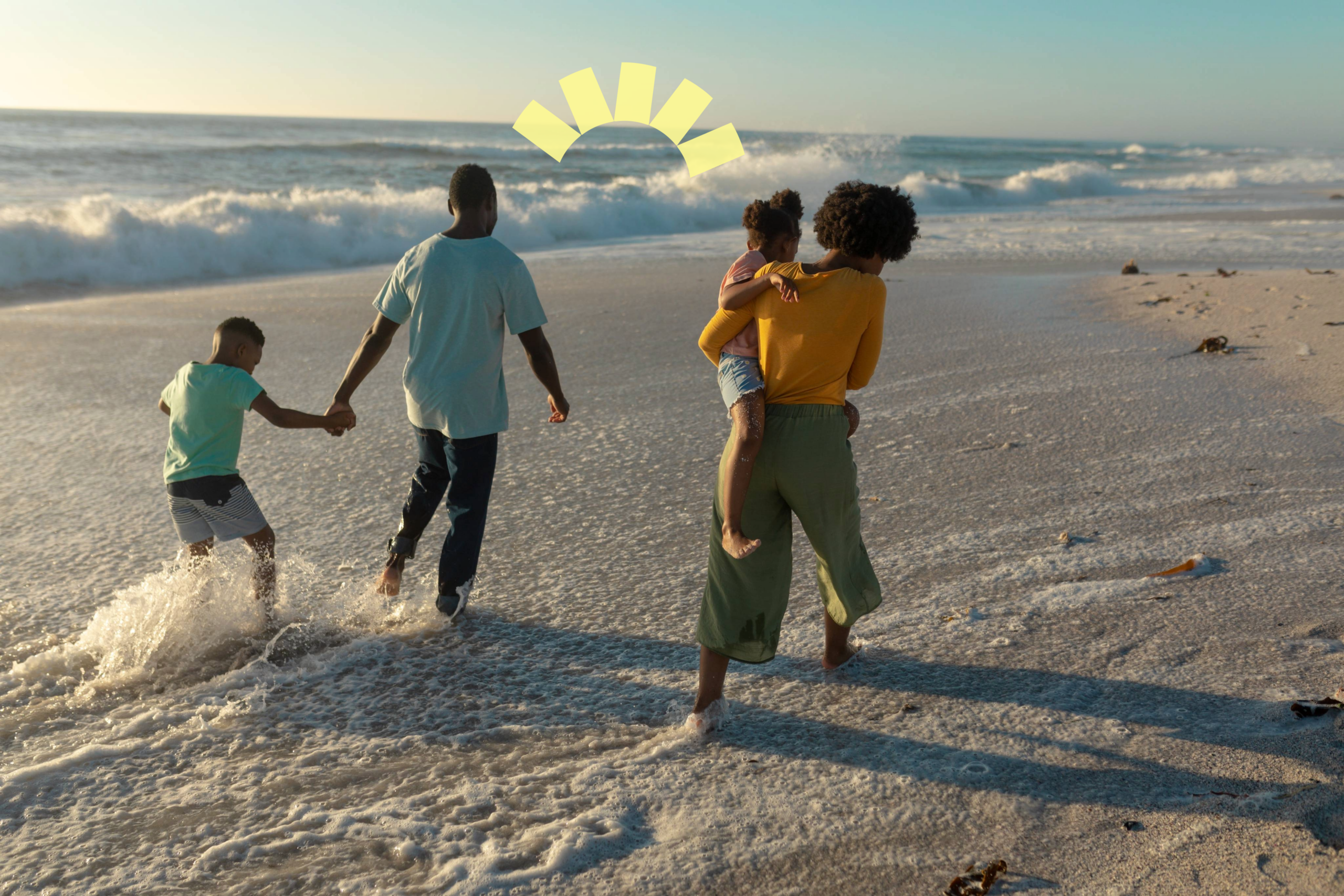 family walking on beach at sunset